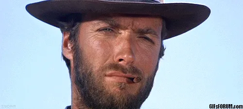Clint Eastwood squinting under the brim of a hat