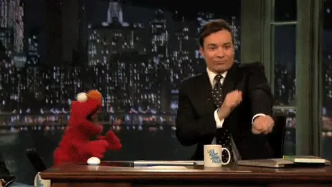 Jimmy Fallon dancing behind his desk on a late night set