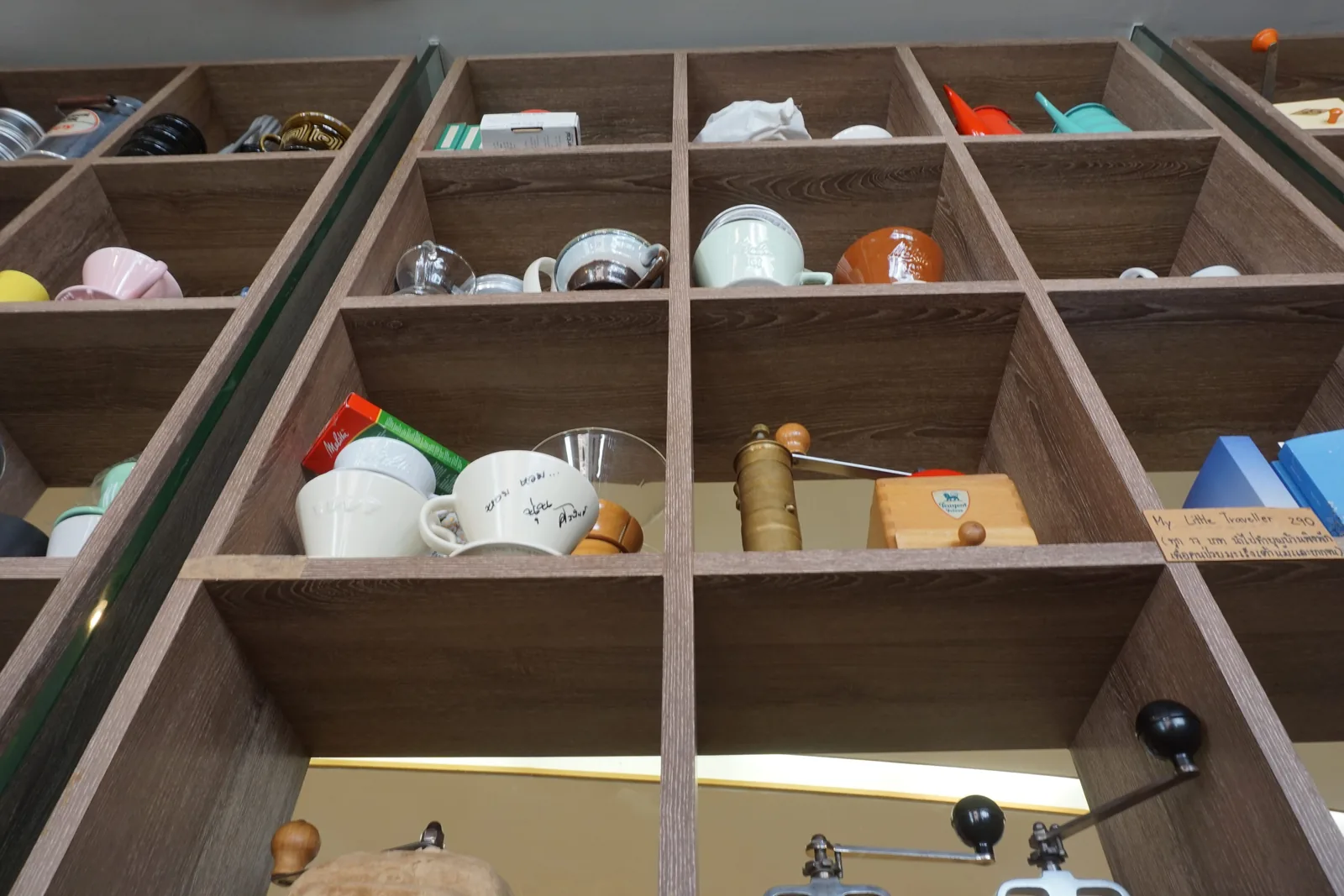 Wooden pigeonholes holding cups, a jar and a brewing scale
