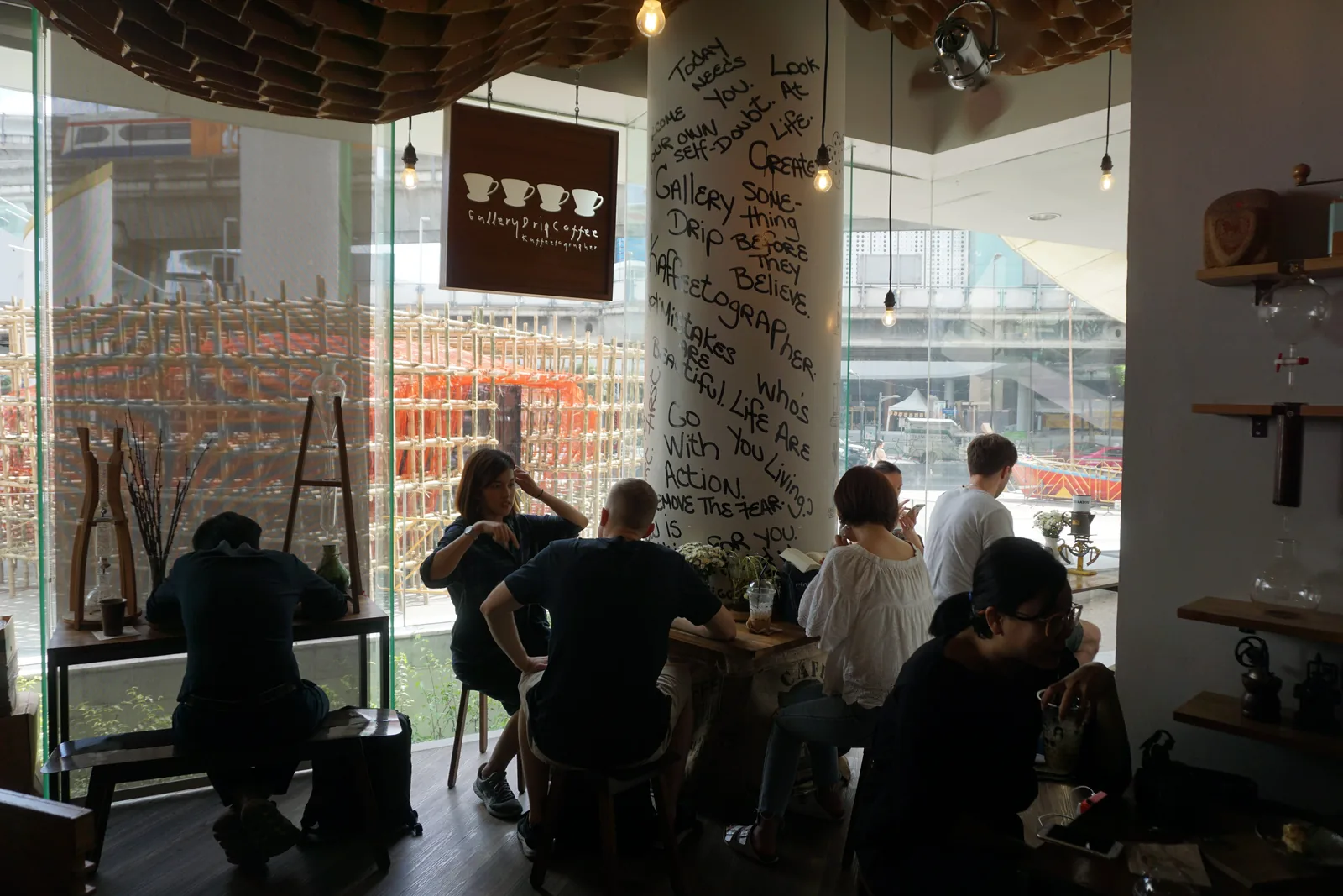Guests at the window counter under the Gallery Drip Coffee sign