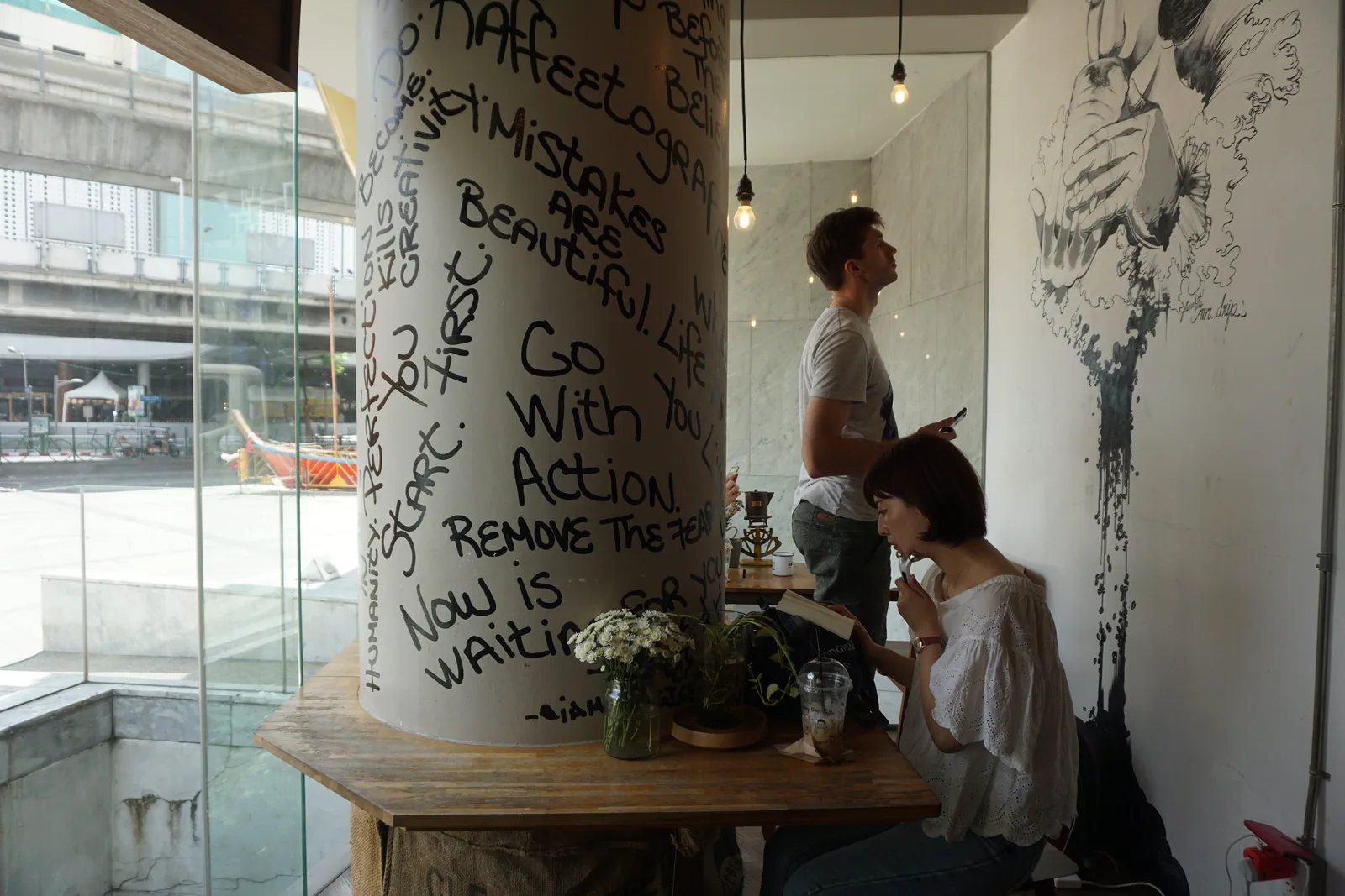 A pillar covered in handwritten notes beside a table at the window