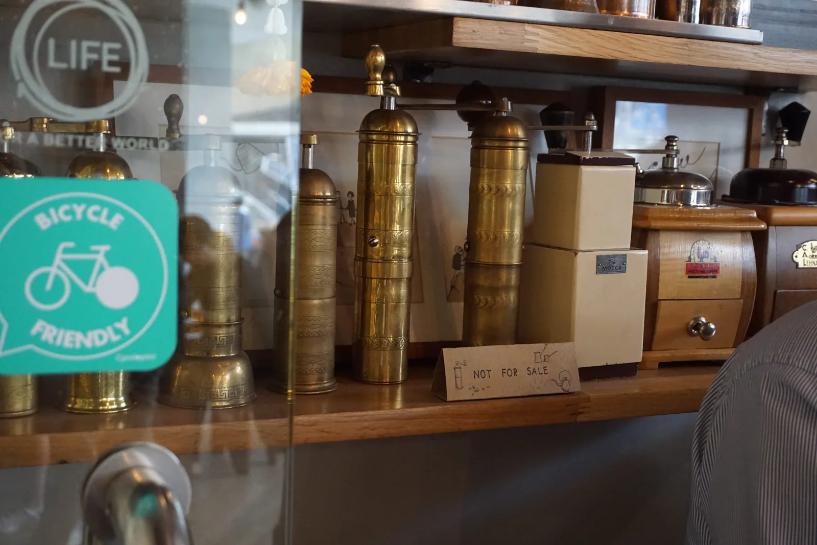 Brass canisters on a shelf beside a Bicycle Friendly sticker