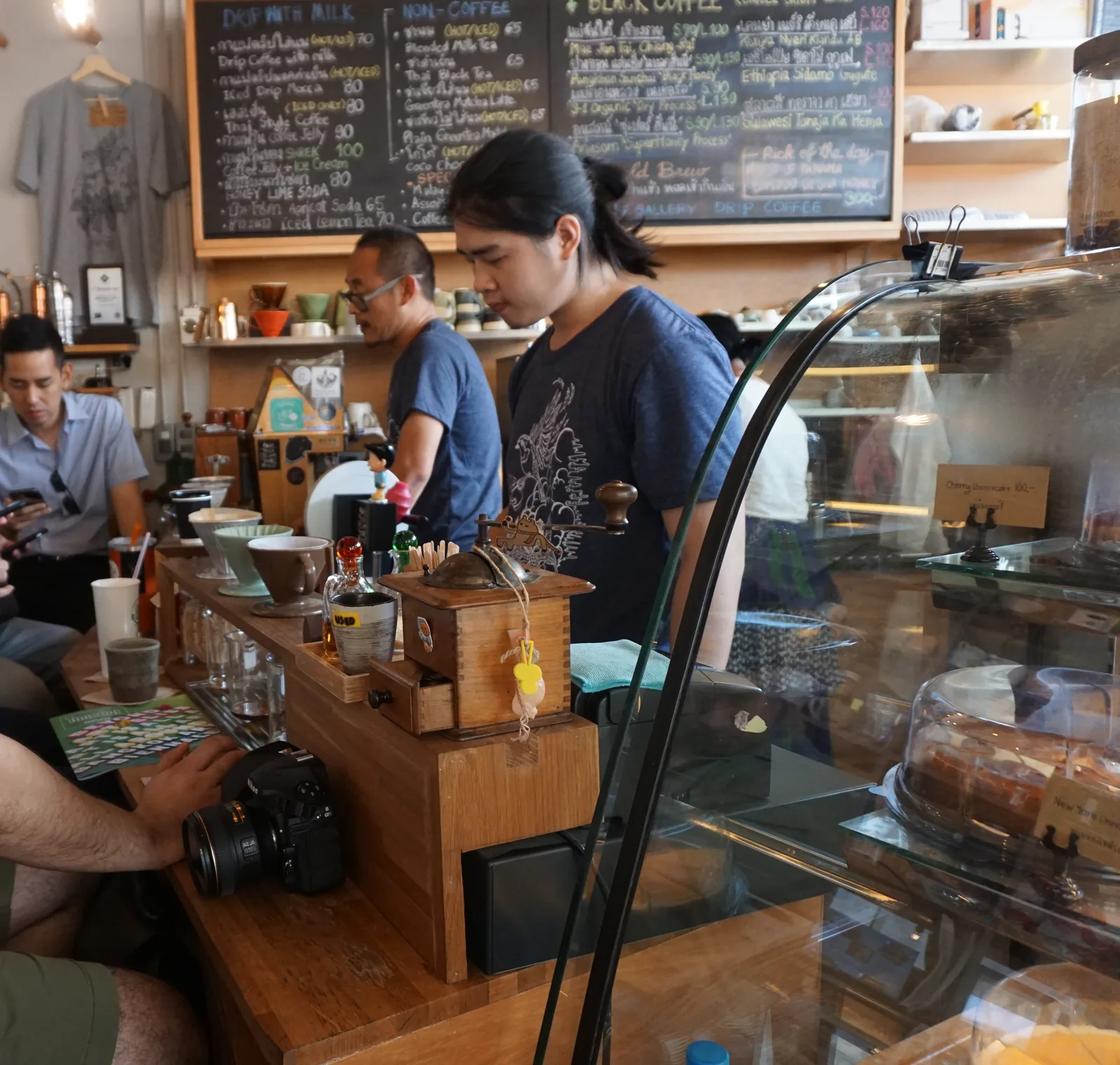 A barista working behind the counter under handwritten menu boards