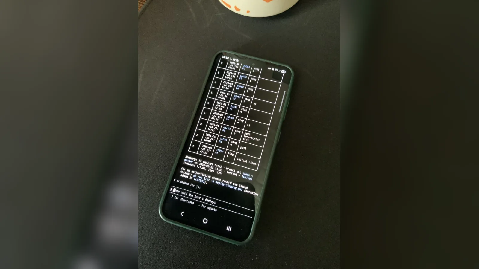 A phone lying on a table showing a terminal keyboard on screen