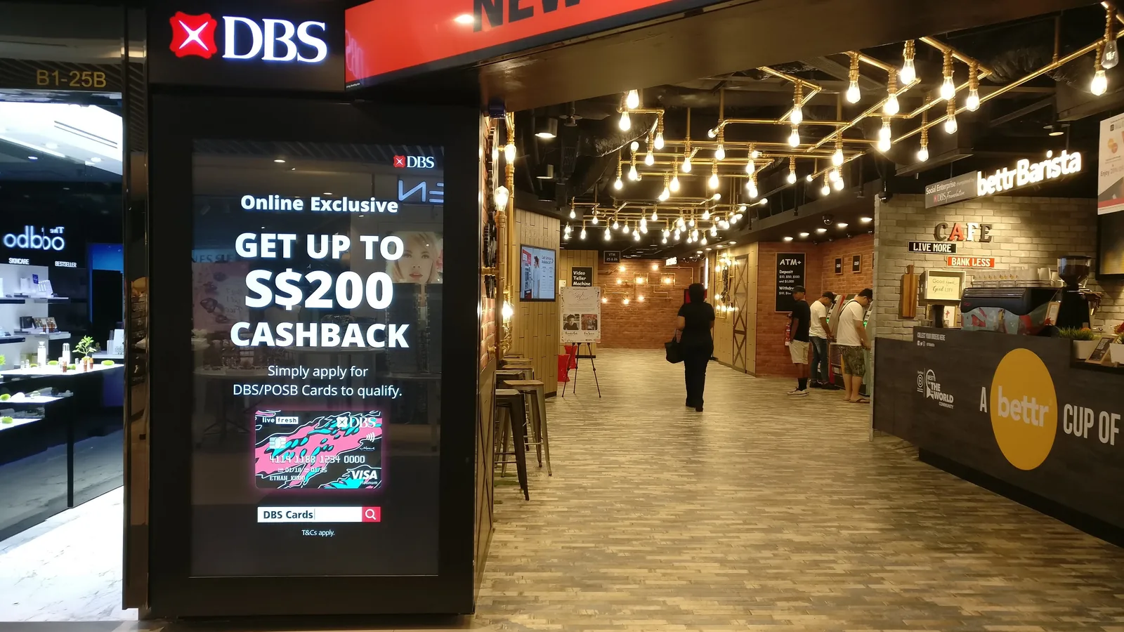 A bank branch with a cashback advertisement on a screen and a coffee bar inside
